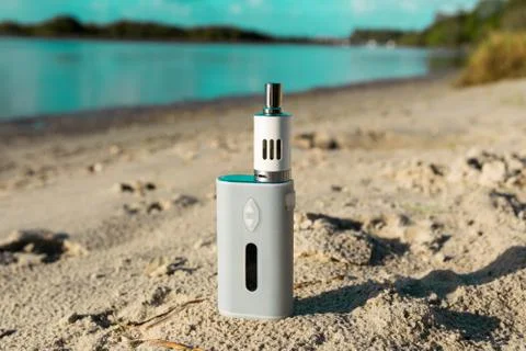 White Electronic Cigarette mod on the beach Stock Photos