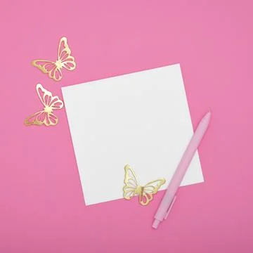 White empty card for your text with pen and golden butterfly on pink backgrou Stock Photos