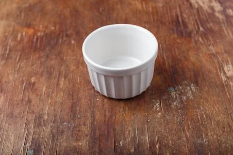 White empty ceramic bowl on old rustic brown wooden table background. Close up Stock Photos