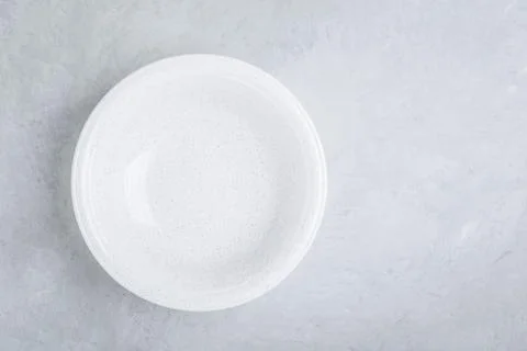White empty ceramic plate on gray concrete or stone background. Stock Photos