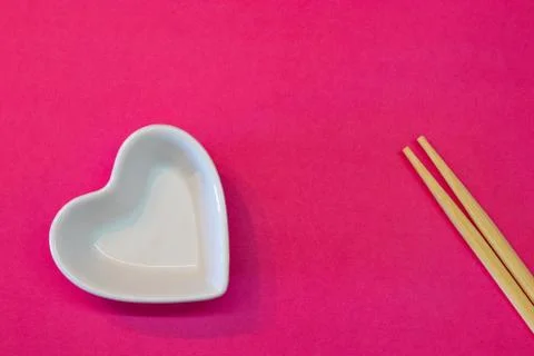 White empty ceramic plate on a pink background with chopsticks. Sushi valenti Stock Photos