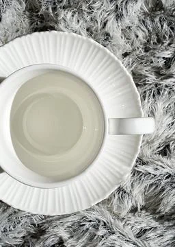 White empty coffee cup on a white winter scarf. Stock Photos