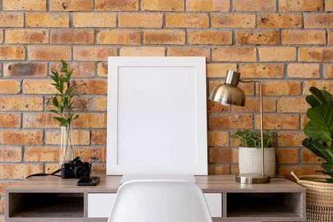 White empty frame with copy space, plants and technology devices on desk against Stock Photos