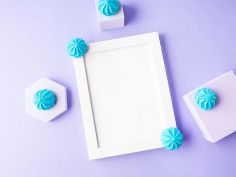 White empty frame on purple background with blue sweet decor, festive flat lay Stock Photos