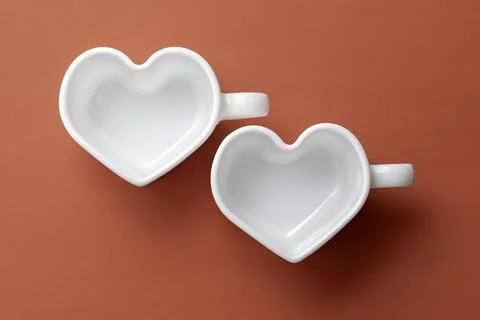 White empty heart-shaped cups on a red background.Top view Stock Photos