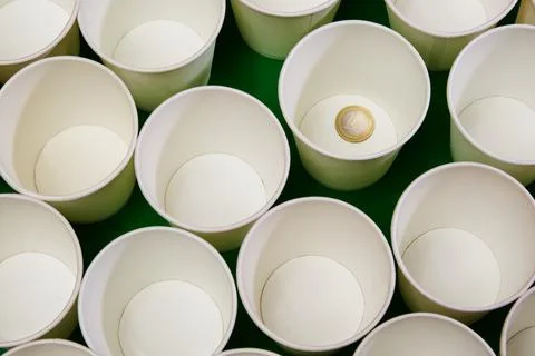 White empty paper cups, one of which contains a 1 euro coin. Leave a donation Stock Photos