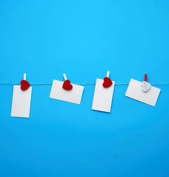 White empty paper rectangular business cards on decorative clothespins with a Fotos Stock