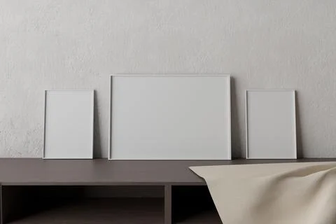 White empty picture frames on wooden table in font of concrete background Illustrazione stock