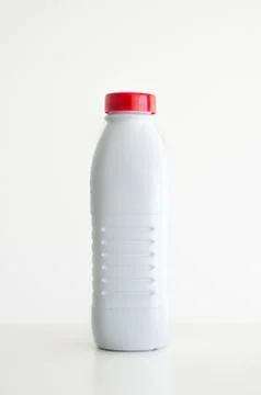 White empty plastic bottle with a red cap against white background Stock Photos