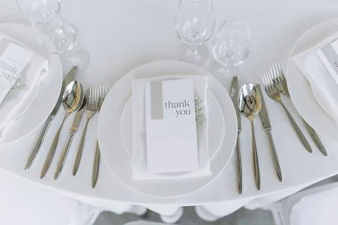 White empty plates with fork, spoon and knife, on white tablecloth. a round.. Stock Photos