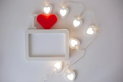 A white empty rectangular photo frame with a red heart at a white background. 写真素材