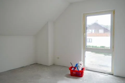White empty room with attic ceiling,French window,gray concrete floor.Red basket Stock Photos