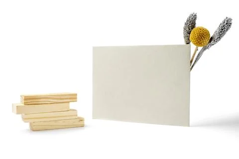 White envelope and postcard with stack of wooden blocks and flowers on whit.. Stockfoto's