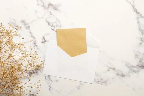 A white envelope with a brown paper inside on a marble kitchen counter Stock Photos