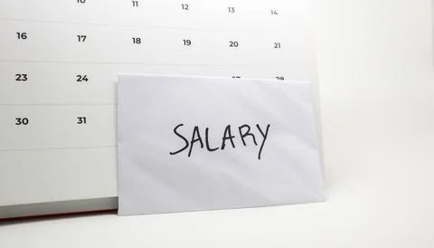White envelope labeled "SALARY" placed against a monthly calendar, represen.. Stock Photos