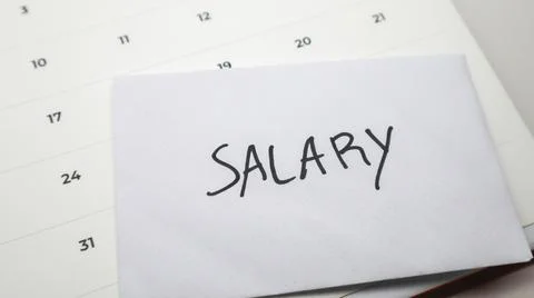 White envelope labeled "SALARY" placed against a monthly calendar, represen.. Stock Photos