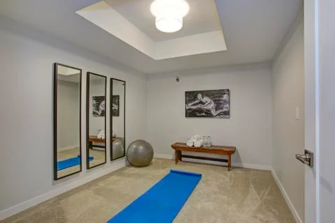 White exercise room with a bench, mirrors and workout accessories Stock Photos