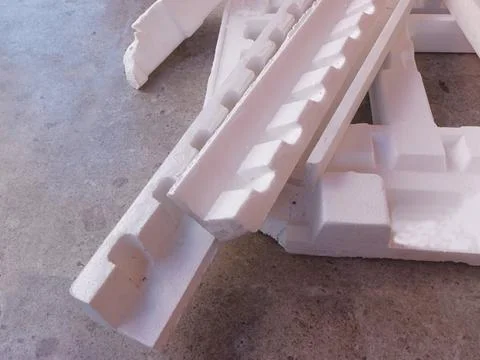 White Expanded Polystyrene Foam Packaging Fragments on Concrete Floor Stock Photos