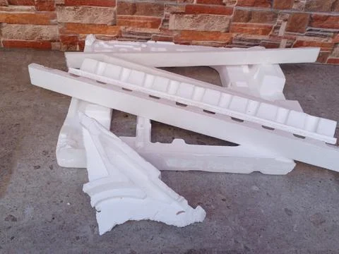 White Expanded Polystyrene Foam Packaging Fragments on Concrete Floor Stock Photos