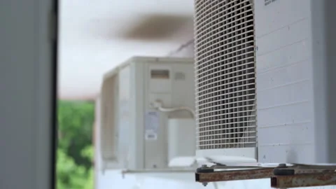 White external air conditioner units mounted outside on wall turning fan closeup Stock Footage 138167339