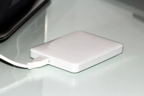 White external hard disk connected with usb cable to the pc resting on the de Stock Photos