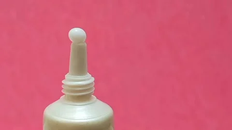 White Eye Cream Texture Squeezed from Tube on Pink Background, Skincare Closeup Stock Footage 325417830