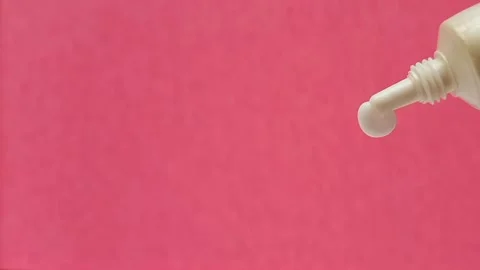 White Eye Cream Texture Squeezed from Tube on Pink Background, Skincare Closeup Stock Footage 325417832