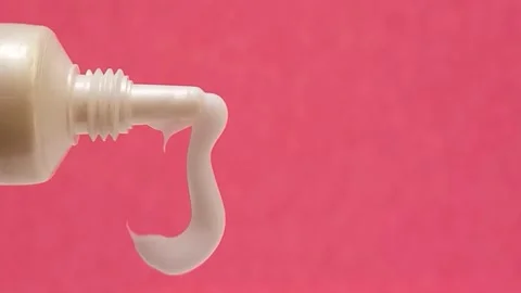 White Eye Cream Texture Squeezed from Tube on Pink Background, Skincare Closeup Stock Footage 325417834