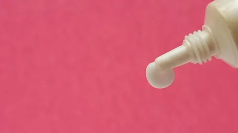 White Eye Cream Texture Squeezed from Tube on Pink Background, Skincare Closeup Stock Footage 325417835