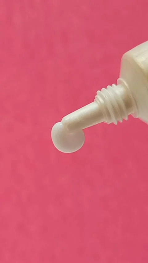 White Eye Cream Texture Squeezed from Tube on Pink Background, Skincare Closeup Stock Footage 325417837