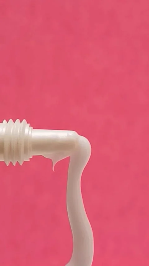 White Eye Cream Texture Squeezed from Tube on Pink Background, Skincare Closeup Stock Footage 325417840