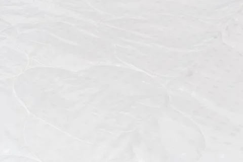 White fabric blanket close-up backdrop with selective focus and background blur Stock Photos