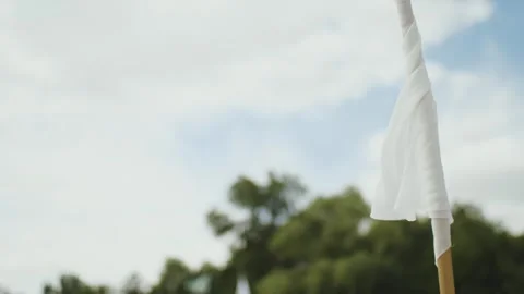 A white fabric flag fluttering on a beach window, a white flag against the sky Stock Footage 308853294