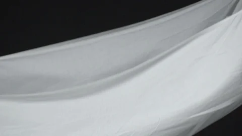 White Fabric floating in super slow motion on a dark black background Stock-Footage 87766003