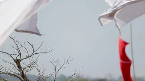 White fabric fluttering with red flag in blurred background Video stock 331276897