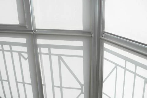 White fabric roller blinds on the plastic window on a balcony in the living room Stock Photos