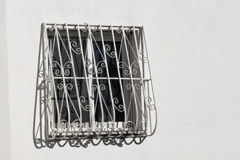 White facade with window and wrought iron railing. Front view of cozy window  Stock Photos