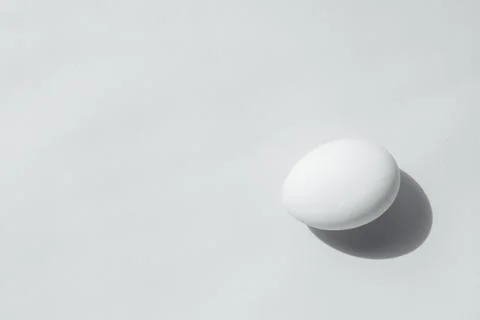 A white face lies at the edge of the frame. The egg is a beautiful regular shape Stock Photos
