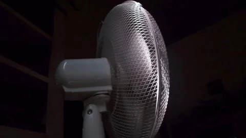 White fan blowing the wind in a dark room on a hot summer day. Stock Footage 247010068