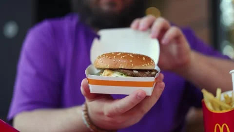 White fat man with beard opens Big Mac burger box with logo of Fifa World Cup Stock Footage 340428117