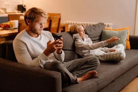 White father and son using cellphone and watching tv at home Fotos Stock