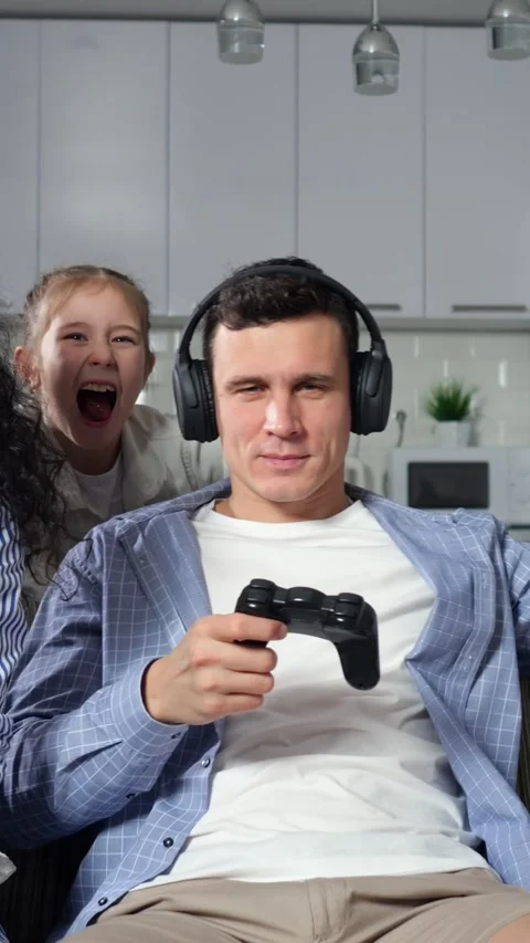 White Father Tired On Couch Gaming, Headphones On, Controller In Hands, Children Stock Footage 335522475