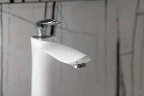 A white faucet with a silver handle Photos