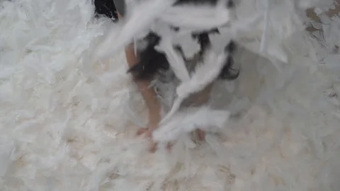 White feathers in the air falling down while girl taking them in the air Stock Footage 124280432