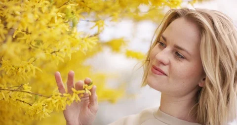 White female exploring a yellow blooming tree Video stock 106580477