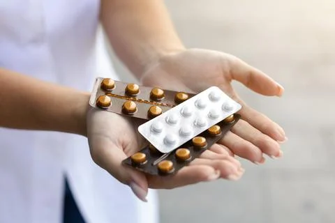 White female hands holding several packages of pills outside Stock Photos