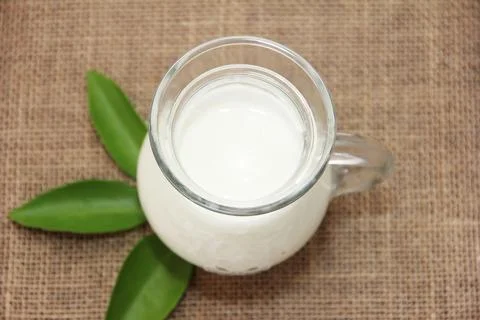 White fermented milk drink ayran in a transparent glass mug in the form of a jug Stock Photos
