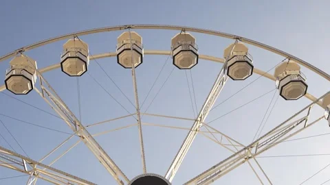 White Ferris Wheel Against a Clear Blue Sky on a Bright Sunny Day Stock Footage 297011901