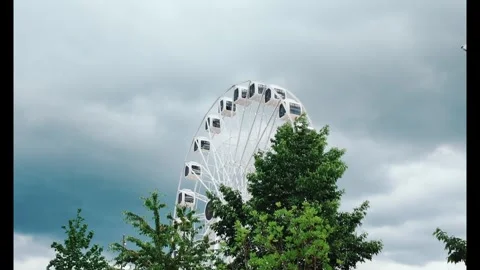 White ferris wheel rotates against clean blue sky Stock Footage 336448199
