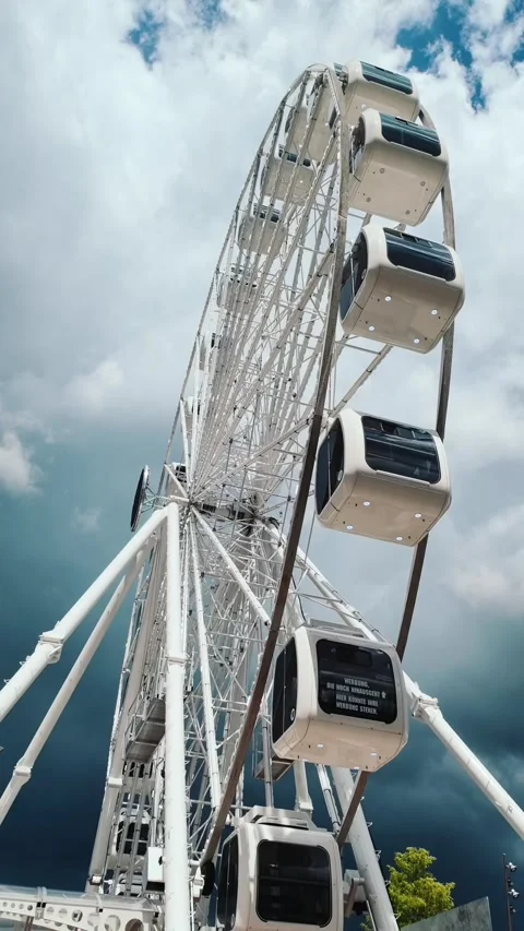 White ferris wheel rotates against clean blue sky 스톡 동영상 336448203